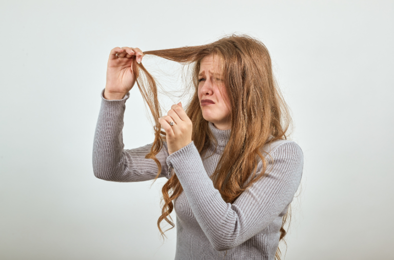 femme tenant ses cheveux cassés
