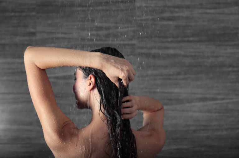 femme touchant ses cheveux sous la douche