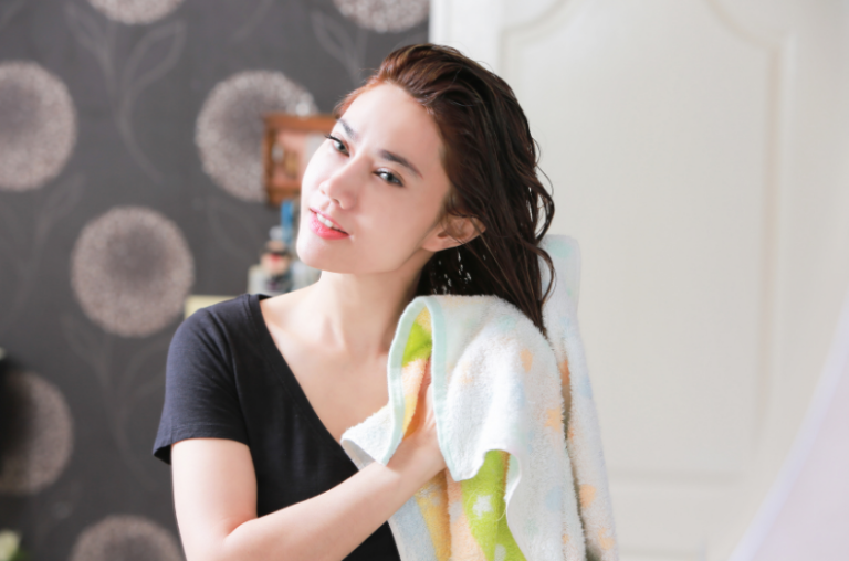 femme de face séchant ses cheveux avec une serviette