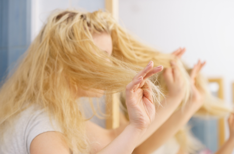 femme tenant ses pointes de cheveux sèches dans une main