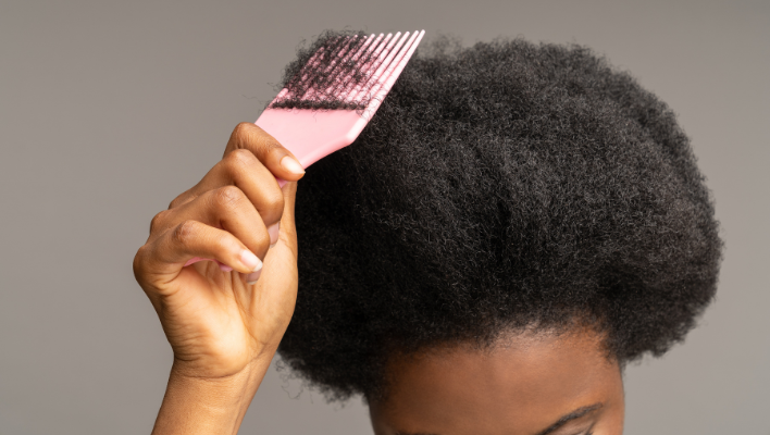 femme utilisant une brosse pour cheveux afros crépus
