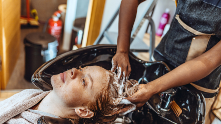 coiffeur faisant un deuxième shampoing à une cliente