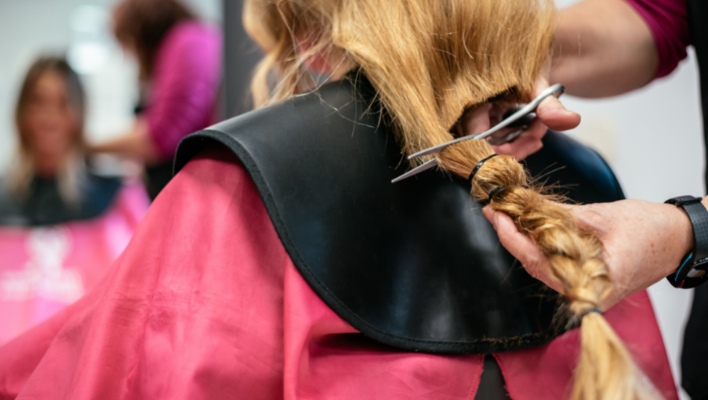 coiffeur coupant les cheveux d'une cliente pour les donner