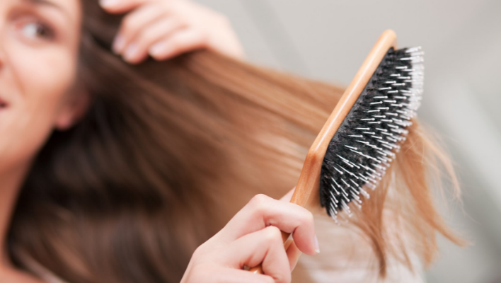 femme brossant ses cheveux avec une brosse à picots