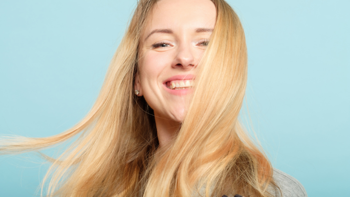 femme souriante aux cheveux blonds brillants