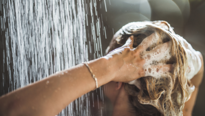 femme faisant mousser du shampoing sur ses cheveux