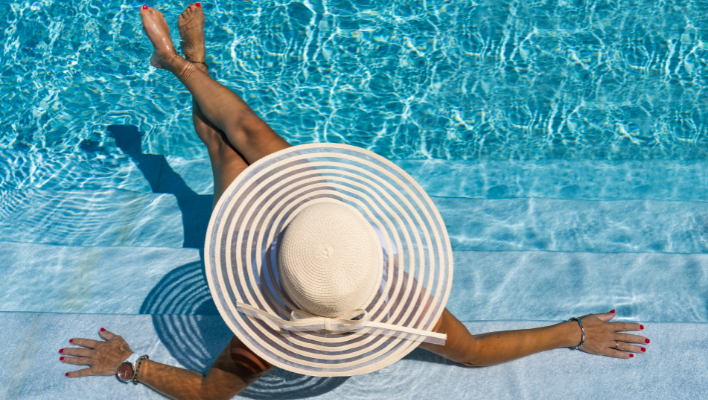 femme portant un chapeau pour protéger ses cheveux du soleil en été à la piscine
