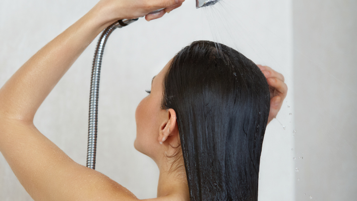 femme rinçant son après-shampoing