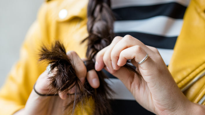 femme faisant une tresse avec ses cheveux