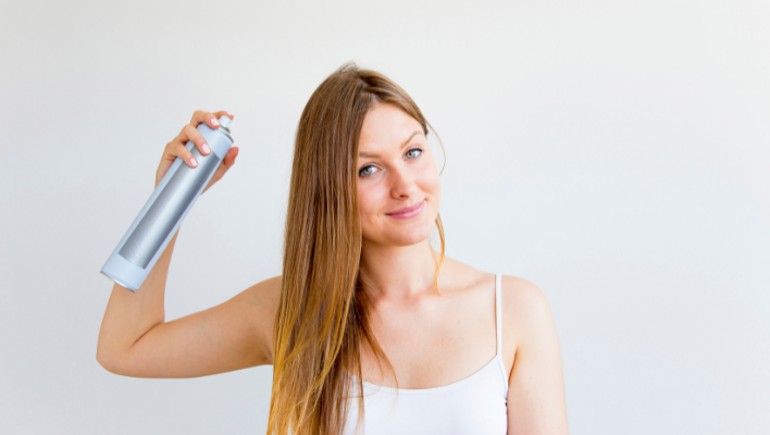 femme utilisant un shampoing sec pour gagner en volume